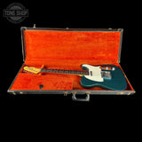 Blue electric guitar in an open red case with 'Tone Shop' logo.