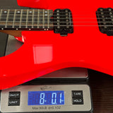Red electric guitar on a digital scale displaying weight