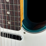 Close-up of a guitar's neck and headstock with a blue pickguard.