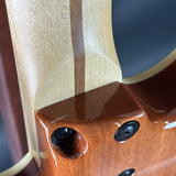 Close-up of a wooden guitar neck with a dark finish