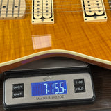 Digital scale displaying weight of a guitar on a wooden surface
