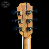 Close-up of a guitar headstock with tuning pegs on a black background, featuring the Tone Shop logo.