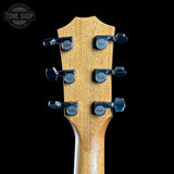 Guitar headstock with tuning pegs on a black background, featuring the Taylor logo.