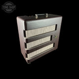A vintage-style guitar amplifier speaker cabinet with a dark brown textured exterior, cream mesh grilles, and a top handle, shown against a solid black background. A 'TONE SHOP' watermark is visible in the top-left corner.