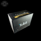 A black guitar amplifier head photographed at an angle on a solid black background, with a gold control panel on top and a Tone Shop watermark in the upper left corner.