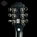 Guitar headstock with tuning pegs on a black background, featuring the Tone Shop logo.