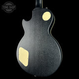 Black electric guitar with gold pickguard on a black background, featuring 'Tone Shop' logo.