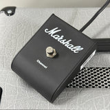 A Marshall Channel guitar effects pedal in matte black with a silver footswitch, resting on a textured gray surface.