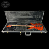 Electric bass guitar in a black case with 'Tone Shop' logo.