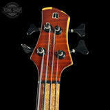 Close-up of a bass guitar headstock with a brand logo on a black background