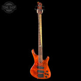 Orange electric bass guitar on a black background with 'Tone Shop' logo.