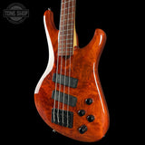 Electric bass guitar with a glossy finish on a black background, featuring the Tone Shop logo.