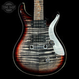A close-up of an electric guitar body against a black background, showing a flame maple top with a split finish effect: dark brown and black wood grain on one side, and a bright reddish-brown sunburst on the other. A white pickguard surrounds the pickups and controls.
