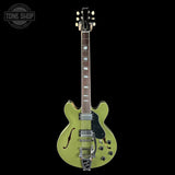 Green electric guitar on a black background with 'Tone Shop' logo.