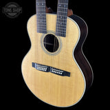 Acoustic guitar with a visible brand logo on a black background