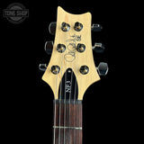 Close-up of the headstock of a guitar against a black background, showing a light natural wood headstock with six black tuning pegs, a black pickguard, and the text 'QALIF & YASIN' and 'NF3'. A Tone Shop watermark is visible in the top left corner.
