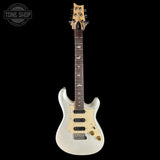 A white electric guitar with a dark brown fretboard and gold hardware, shown against a solid black background. A Tone Shop watermark is visible in the top-left corner.