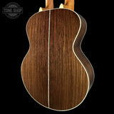 Close-up of a wooden acoustic guitar back with 'Tone Shop' logo.