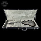 Electric guitar in an open hard-shell case with 'Tone Shop' logo.