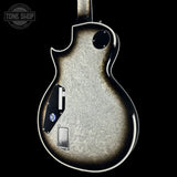 Close-up of a guitar's back with a 'Tone Shop' logo in the corner.