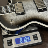 Electric guitar on a digital scale displaying weight