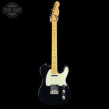 A classic Fender Telecaster electric guitar with a black body, cream pickguard, and natural maple neck, shown against a solid black background with a Tone Shop watermark in the top-left corner.