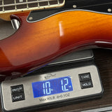 Guitar on a digital scale displaying weight