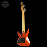 A Fender electric guitar shown from the back, featuring a vibrant orange-brown sunburst finish, maple neck, and black pickups, set against a solid black background with a Tone Shop watermark in the top left corner.