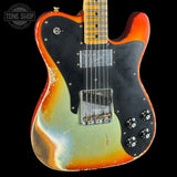 Electric guitar with a multicolored finish on a black background, featuring the Tone Shop logo.