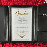 Fender certificate of authenticity inside a black leather case on a red background