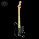 A black electric guitar with a maple neck and headstock, shown vertically against a solid black background. A Tone Shop watermark is visible in the top-left corner.
