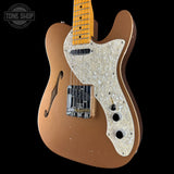Brown electric guitar with a pearlized pickguard on a black background, featuring 'Tone Shop' branding.