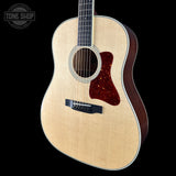 Acoustic guitar with a visible brand logo on a black background