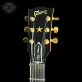 Gibson guitar headstock with 'Tone Shop' logo in the corner
