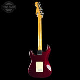 A Fender electric guitar shown from the back, featuring a glossy dark red body, a natural maple neck, and a cream pickguard, set against a solid black background with a Tone Shop watermark in the top-left corner.