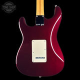 Rear view of an electric guitar with a glossy dark red body, cream pickguard, and a light wood neck, shown against a black background with a Tone Shop watermark in the top left corner.