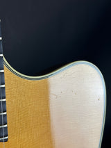 Close-up of an acoustic guitar's soundhole and neck on a black background