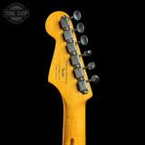 Close-up of the headstock of a Fender electric guitar in a natural maple finish, showing the six tuning pegs and model text, set against a solid black background.