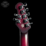 Close-up of the headstock of an electric guitar against a black background, showing six tuning pegs and a glossy dark red to burgundy finish. A Tone Shop watermark is visible in the top left corner.