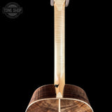 Close-up of the neck and lower body of a stringed instrument, likely a mandolin or small acoustic guitar, showing a light natural wood neck and a dark brown wood body against a black background. A Tone Shop watermark appears in the upper left corner.