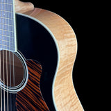 Close-up of an acoustic guitar's body and neck on a black background