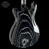 Close-up of the back of an electric guitar body with a glossy black finish and prominent white and gray agate-like natural stone veining pattern, shown against a solid black background. A Tone Shop watermark is visible in the top-left corner.