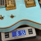 Light blue electric guitar on a digital scale displaying weight.