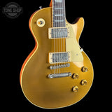 Gold electric guitar on a black background with 'Tone Shop' logo.