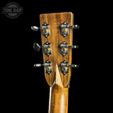 Close-up of a guitar headstock with tuning pegs on a black background, featuring the Tone Shop logo.