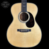 Acoustic guitar with a visible brand logo on a black background