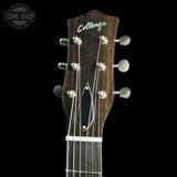 Close-up of the headstock of a Collings acoustic guitar against a black background, showing six silver tuning pegs, six strings, and the brand name 'Collings' in white script. A 'TONE SHOP' watermark is visible in the top-left corner.