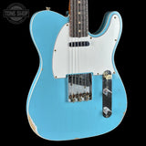 Blue electric guitar with a white pickguard on a black background, featuring the Tone Shop logo.
