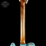Close-up of a guitar neck with a visible brand logo in the corner.