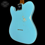 Light blue electric guitar body with visible wear on a black background, featuring the 'Tone Shop' logo.